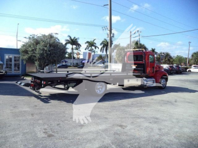 Peterbilt 337 rollback tow truck in service with flatbed visible.