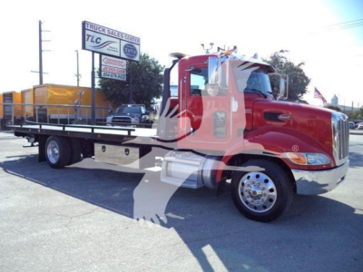 Peterbilt 337 rollback truck in red with flatbed, side view showing cab and chrome bumper.