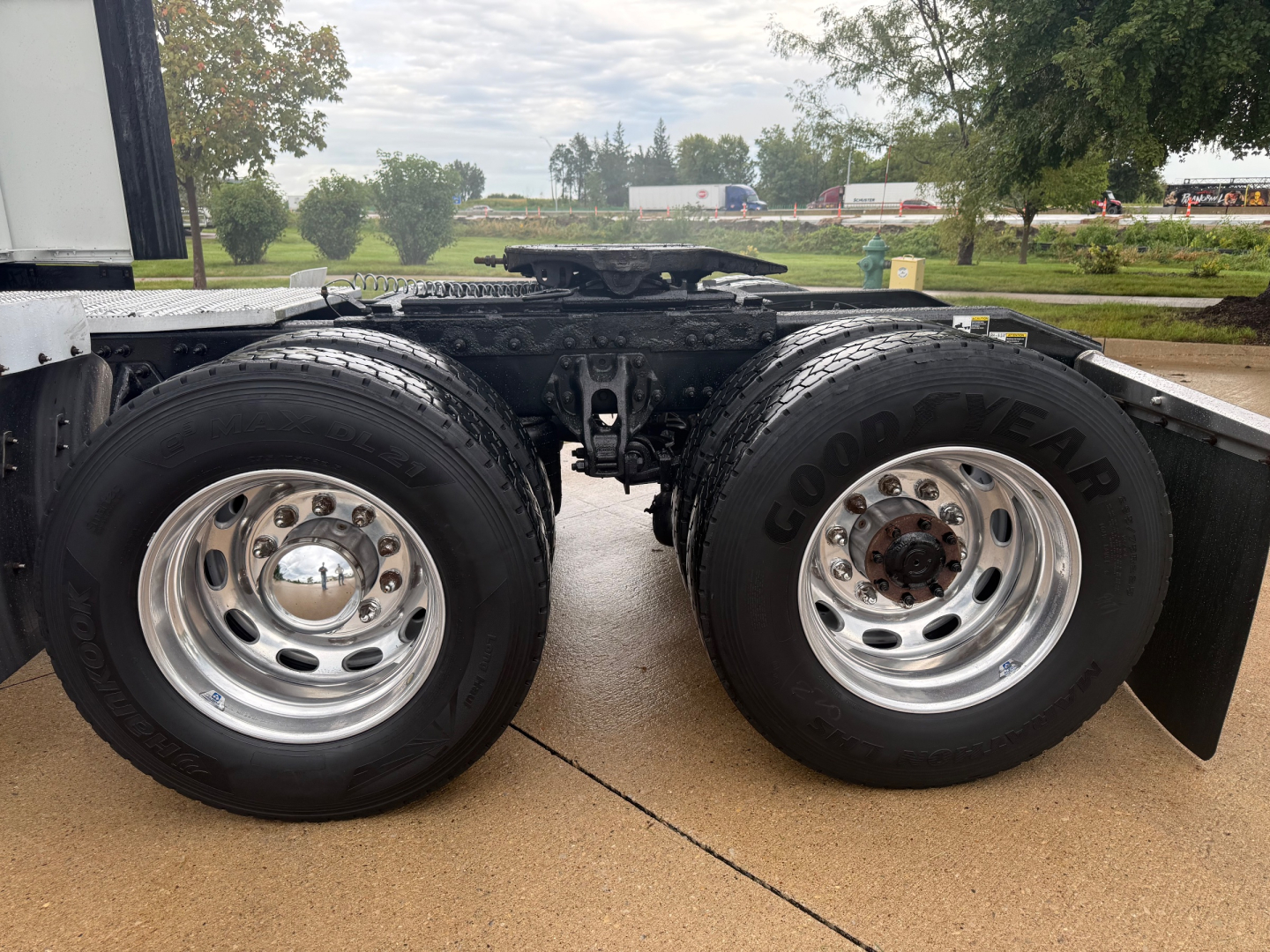 Truck axle and dual rear wheels on Peterbilt 579 chassis showing Goodyear tires and polished rims.
