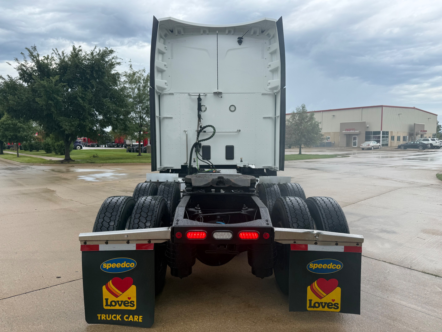 Peterbilt 579 truck rear view showing sleeper cab and dual rear axles with mud flaps and Love's branding.
