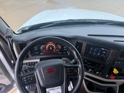 Peterbilt 579 interior dashboard and steering wheel showing instrument cluster and infotainment screen.