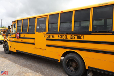 School bus side view showing Central School District lettering and stop sign on yellow Freightliner bus.