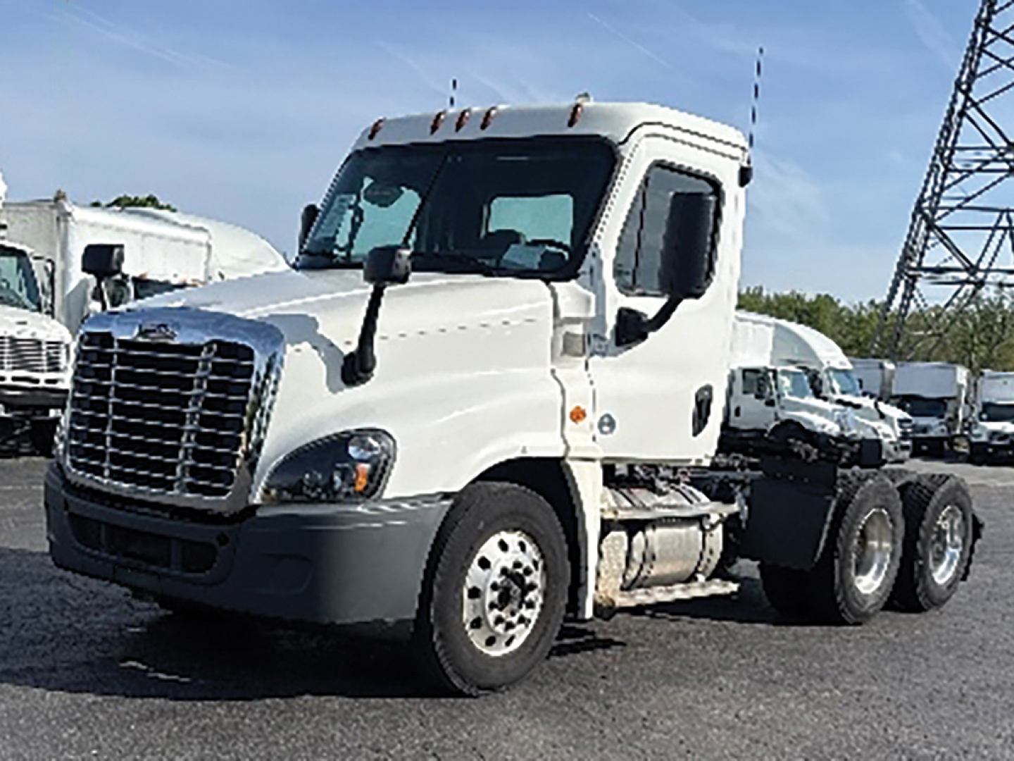 Freightliner Cascadia125 tractor cab in a truck lot showing front and side view with white paint.