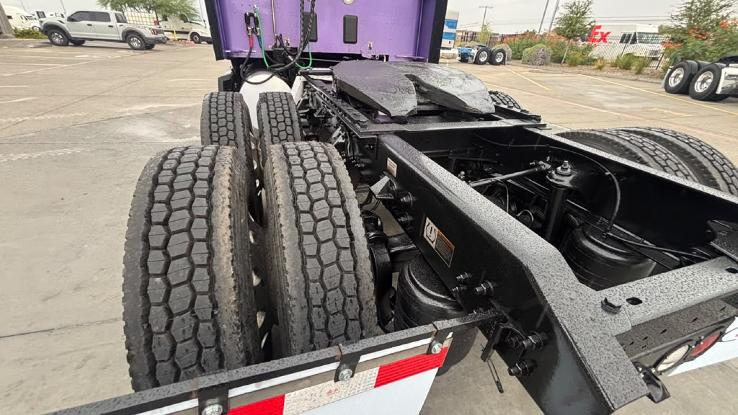 Kenworth T680 truck rear chassis with dual rear axles and rugged tires showing undercarriage view.