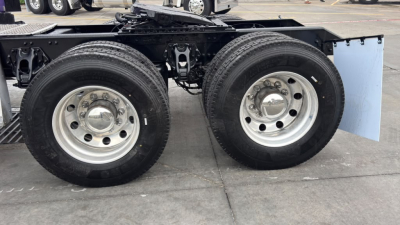 Two rear wheels of a Kenworth T680 tractor showing dual rear axles with metal rims and tires, undercarriage framing visible.