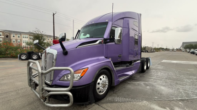 Kenworth T680 sleeper tractor in purple, front grille guard and side mirrors visible, with chrome wheels and dual rear axles.