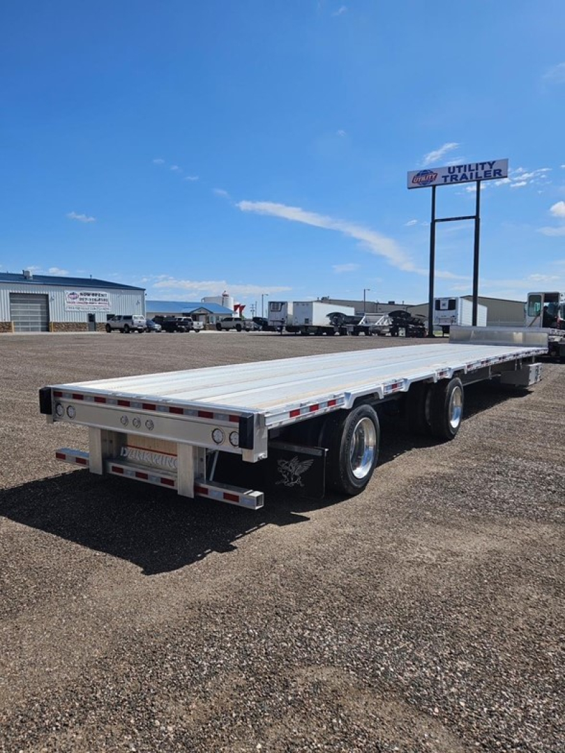 Manac Darkwing 53' drop deck trailer in a lot, with dual rear axles and a long flatbed, side rails and clearance lights visible.