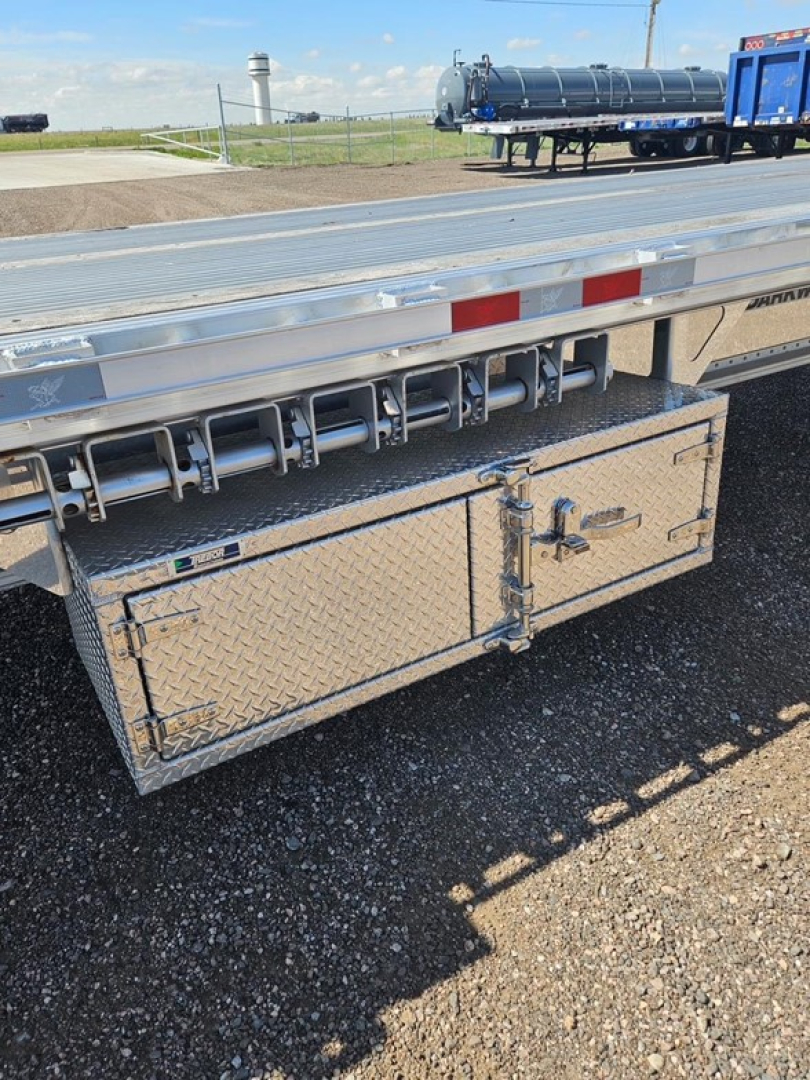Drop deck trailer with aluminum diamond plate toolbox and side access undercarriage view showing storage compartment and rear ladder brackets.