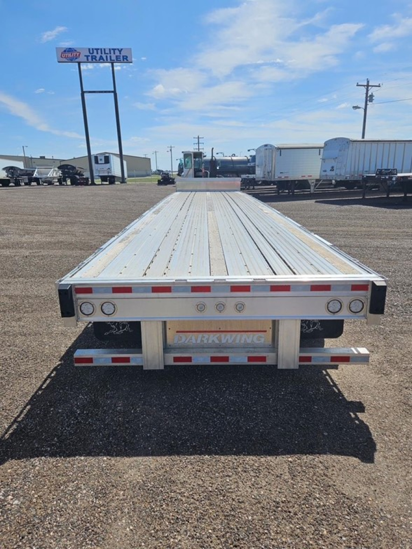 Manac Darkwing 53' drop deck trailer seen from rear, aluminum deck, taillights and bumper visible, drop legs and undercarriage partially visible.