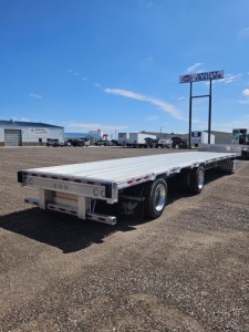 Manac Darkwing 53' drop deck trailer in a lot, with dual rear axles and a long flatbed, side rails and clearance lights visible.