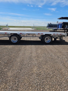 Manac Darkwing 53' drop deck trailer side view showing tandem axles and flatbed deck with side rails.