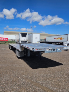 Manac Darkwing 53' drop deck trailer in an outdoor lot, with other trailers in background.