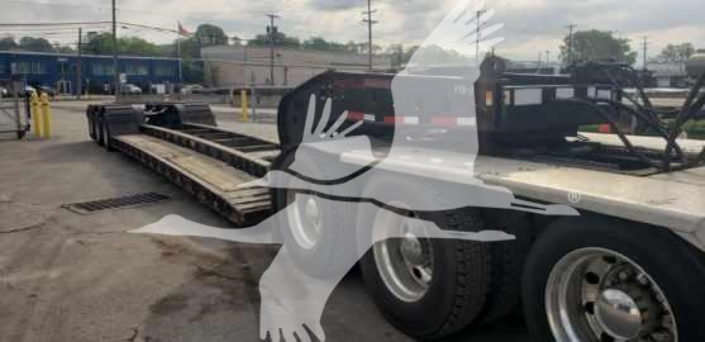 55H-DSR Fontaine lowboy trailer showing dual rear axles and flatbed with reflective tape and wheel rims.