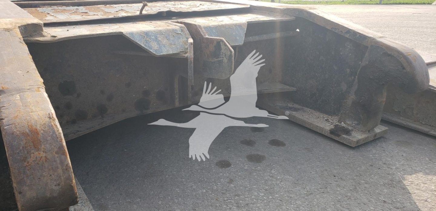 Trailer hitch area of a Fontaine lowboy showing metal frame and coupling pocket with dirty surface and rust-free textless area.