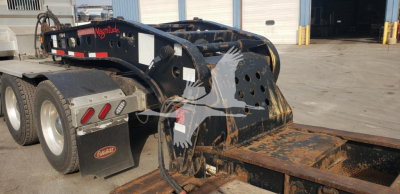Fontaine 55H-DSR lowboy trailer with hydraulic gooseneck and dual rear axles, visible wear and black paint, storage area in background, VIN plate not clearly readable.