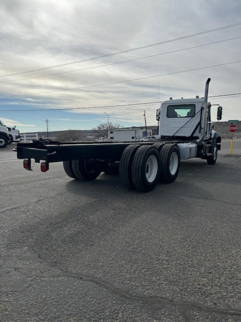 Mack GR64B vacuum tank truck rear and side view showing chassis and dual rear tires with flatbed platform.