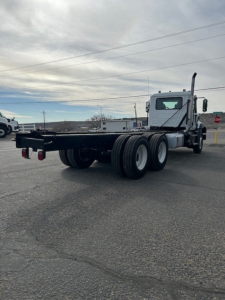 Mack GR64B vacuum tank truck rear and side view showing chassis and dual rear tires with flatbed platform.