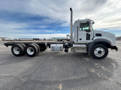 Side view of a 2026 Mack GR64B vacuum tank truck showing sleeper cab, long chassis, dual-drive rear axles, exhaust stack, and fuel tanks.