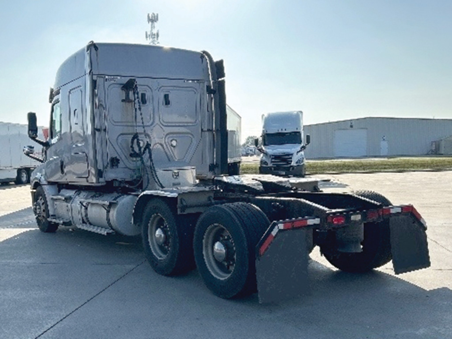 Freightliner Cascadia 126 truck tractor side rear view showing dual rear axles and fifth-wheel connection with no trailer.
