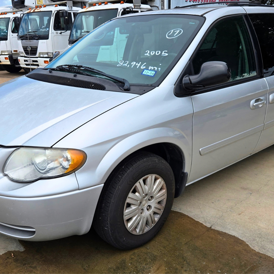 Isuzu FTR cargo van front-left view with shaved hood and windshield writing on glass, showing year 2005 and mileage 329,946 mi.