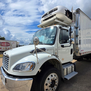 Isuzu FTR medium-duty refrigerated truck with Thermo King cooler on cab, white cab, box trailer, side steps, chrome bumper, parked outdoors.