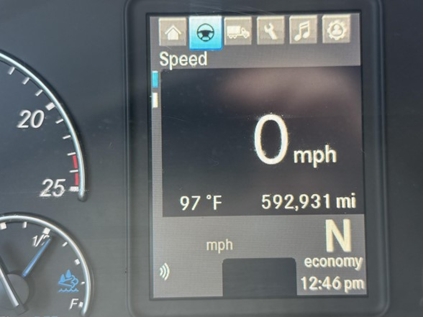 Dashboard display from a Freightliner Cascadia showing Speed 0 mph, outside temperature 97°F, odometer 592,931 miles, gear N, economy indicator, time 12:46 pm.