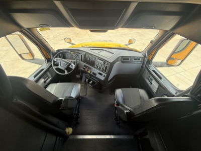 Freightliner Cascadia 126 cab interior view from doorway showing steering wheel, dashboard, and seats