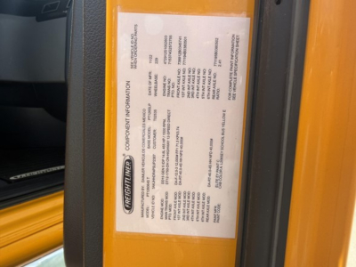 Freightliner Cascadia 126 truck side door sticker visible with vehicle information label and yellow body panel.