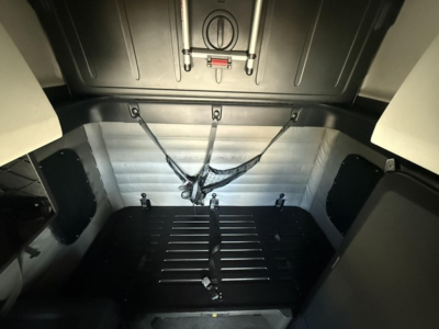Freightliner Cascadia 126 sleeper cab interior cargo area with tie-downs and panels.