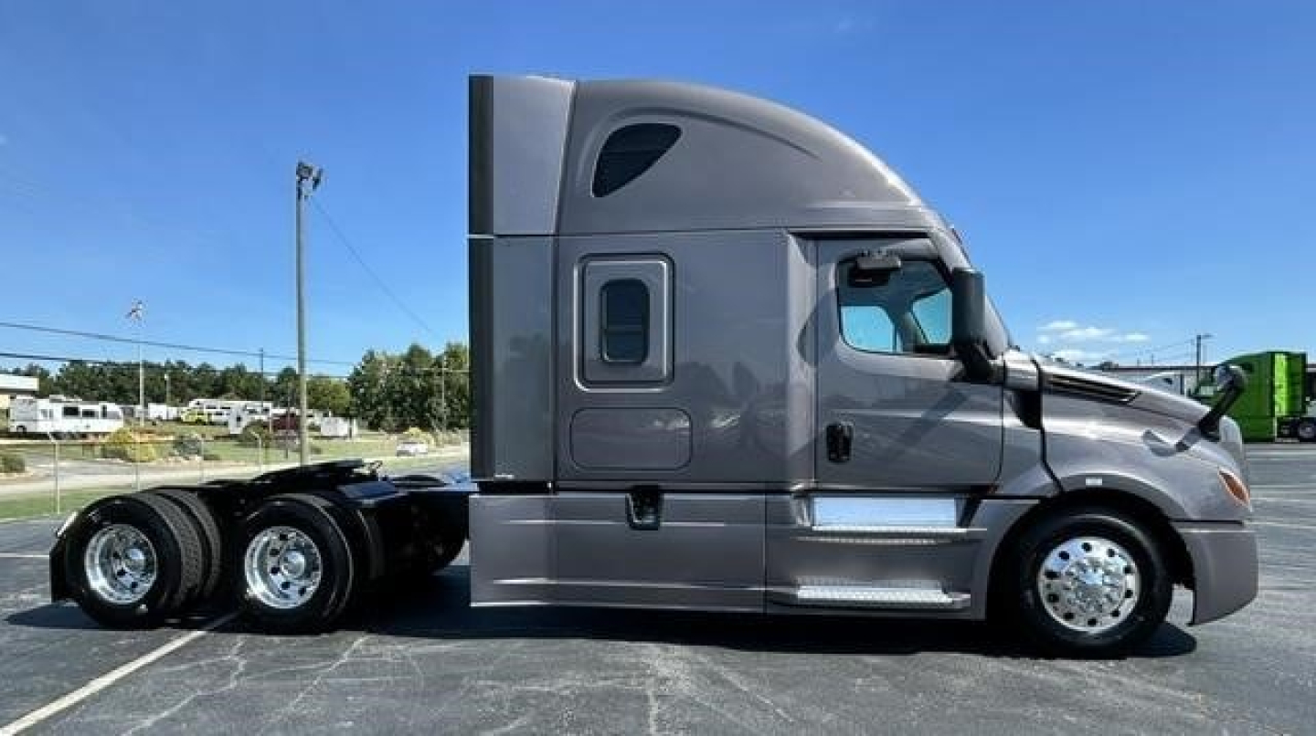 Freightliner Cascadia 126 (2023) side view showing cab with sleeper, chrome wheels, and dual rear axles.