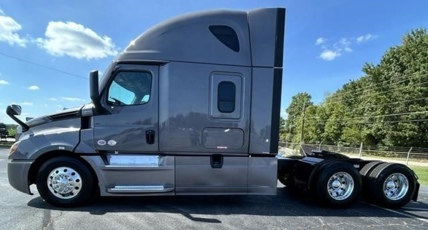 Freightliner Cascadia 126 sleeper tractor side view showing gray exterior, chrome wheels, and rear axles.