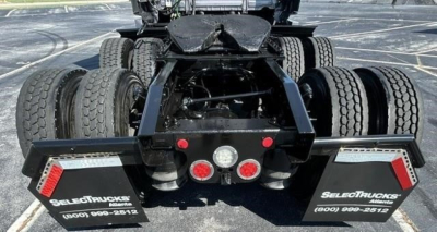 Rear view of a 2023 Freightliner Cascadia 126 tractor showing the fifth wheel hitch, dual rear axles with six wheels, and mirrored mud flaps with SelectTrucks branding.