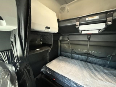 Truck sleeper cab interior with bed mattress, overhead storage, and side panels visible in a Freightliner Cascadia 126.