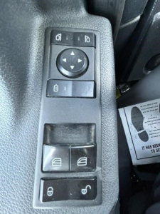 Truck interior control panel with window/mirror adjustment buttons and door lock switches visible.