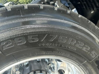 Truck tire with tread and sidewall markings, showing tire size 22.5 16? 235? Not clear. Visible characters include '??'