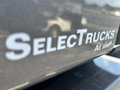 SelectTrucks logo decal and reflection on glossy truck surface.