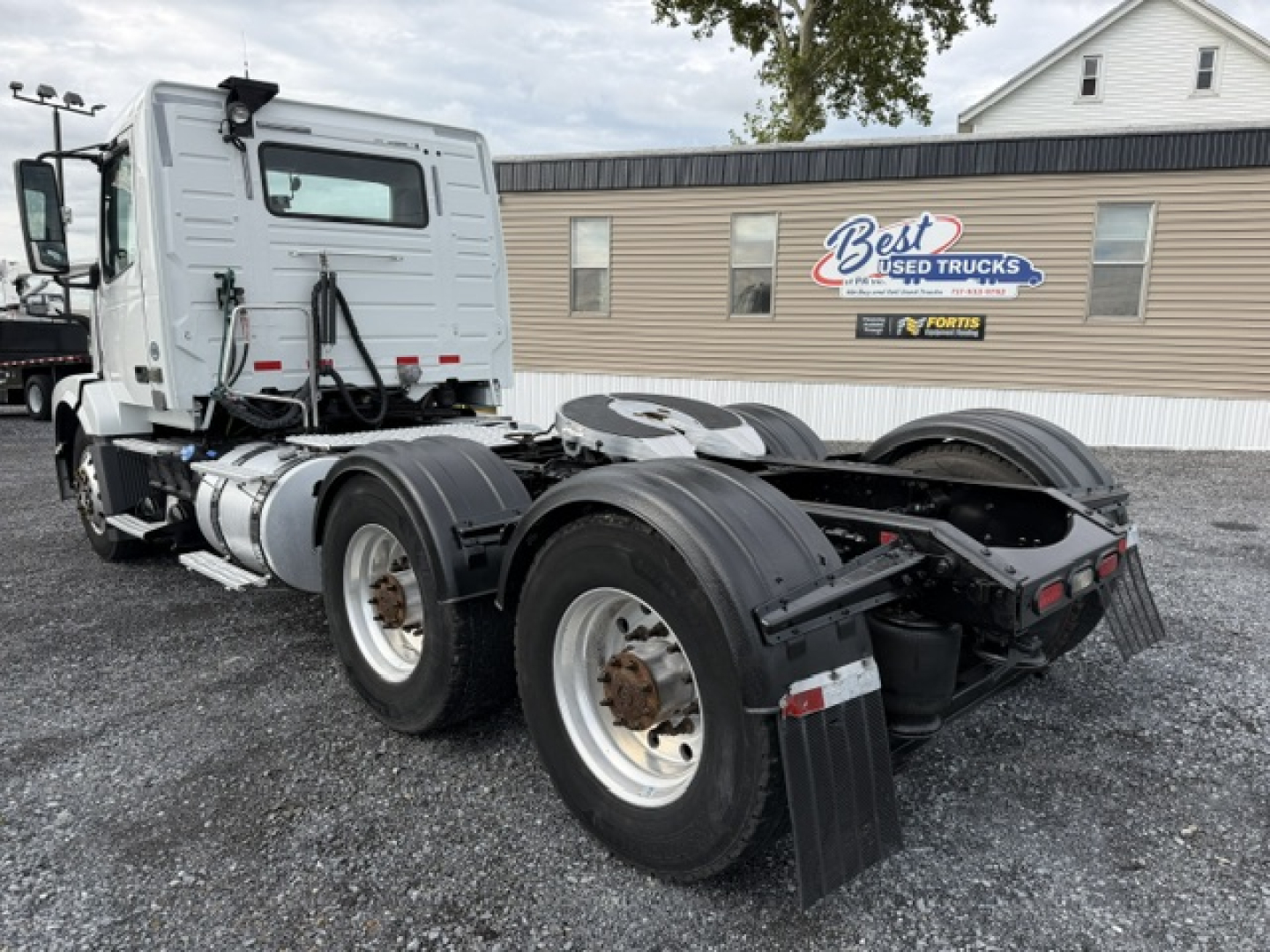 Volvo VNL64T300 tractor truck chassis rear view showing dual rear axles and fifth wheel with fuel tanks and mirrors visible.