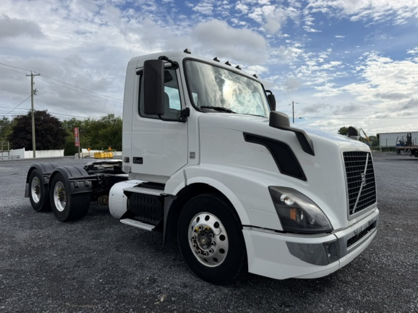 Volvo VNL64T300 truck cab and chassis in white, front left view showing tires and aerodynamic mirrors.