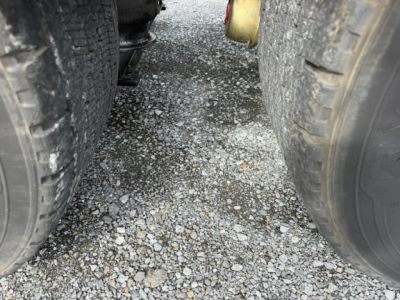 Volvo VNL64T300 truck undercarriage showing dual rear axles and ground between tires.