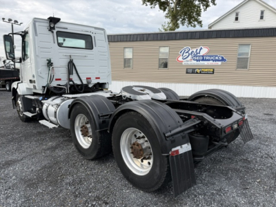 Volvo VNL64T300 tractor truck chassis rear view showing dual rear axles and fifth wheel with fuel tanks and mirrors visible.