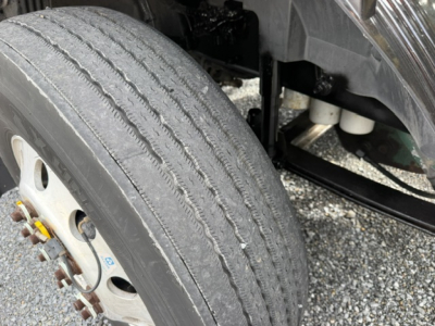 Volvo VNL64T300 wheel and front suspension showing tire tread and wheel hub.