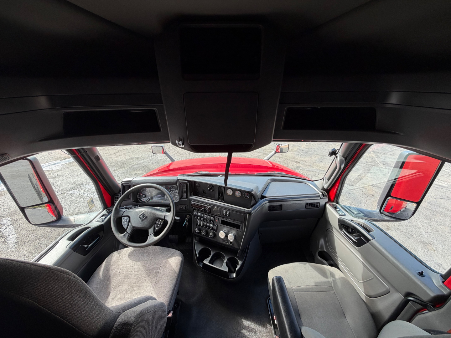 Cab interior of a 2020 International LT625 sleeper truck showing steering wheel, dashboard, center console, and front seats.