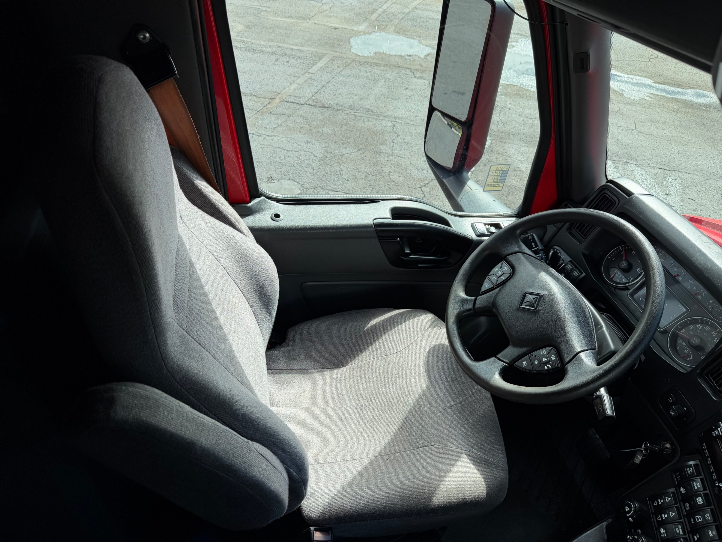 Interior of a 2020 International LT625 truck cab showing steering wheel and driver seat with gray upholstery.
