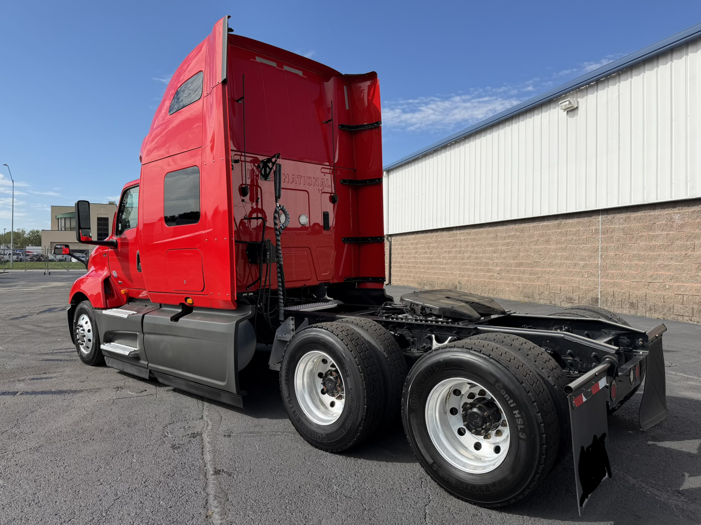2020 International LT625 in red sleeper cab side angle showing rear dual axles and chassis without trailer.