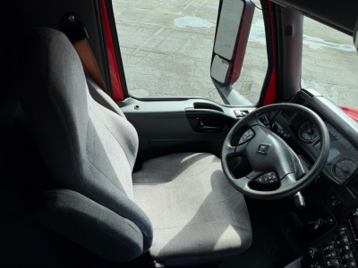 Interior of a 2020 International LT625 truck cab showing steering wheel and driver seat with gray upholstery.