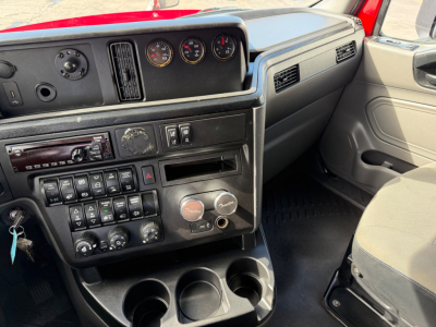 Dashboard area of a 2020 International LT625 truck cabin showing gauges, control switches, and cup holders.