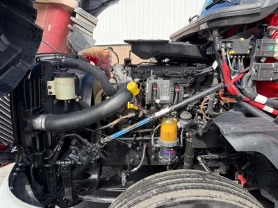 Engine bay of a 2020 International LT625 truck showing various components, hoses, yellow cap, and filters.
