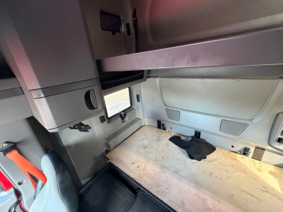 Interior sleeper cab area of a used 2020 International LT625 showing a wooden floor panel and storage cabinets.