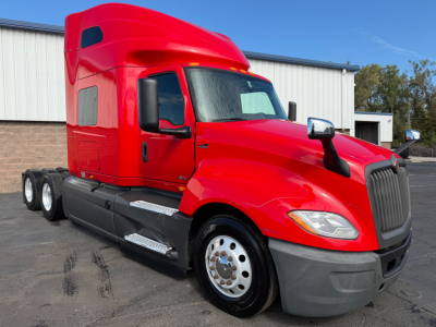 Red International LT Series truck cab with sleeper, side step, and dual rear axles. Front grille and headlights visible; text on image includes no explicit labels.