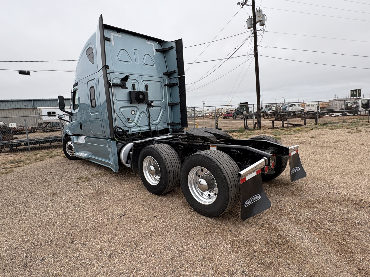 Freightliner Cascadia 126 tractor chassis rear view showing dual rear axles and mud flaps.